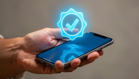 Mão segurando smartphone com selo de verificação azul brilhante.